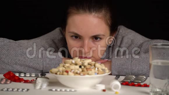 女孩用勺子吃碗里的药片药品视频的预览图