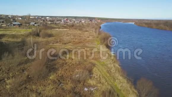 自然景观与宽阔的河流和田野与黄草和雪在早春剪辑小型飞机视频的预览图