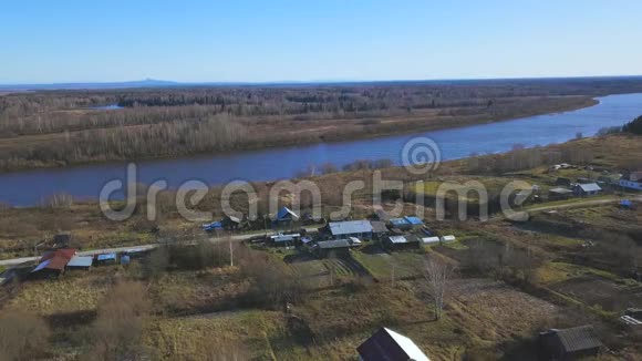 空中小村庄罕见的房屋和美丽的河流沿着海岸流动剪辑在乡村上空飞翔视频的预览图