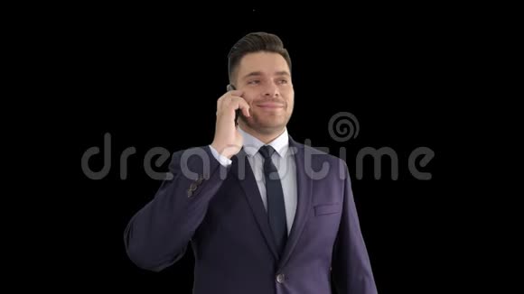 微笑的年轻商人有电话与他的手机阿尔法频道视频的预览图