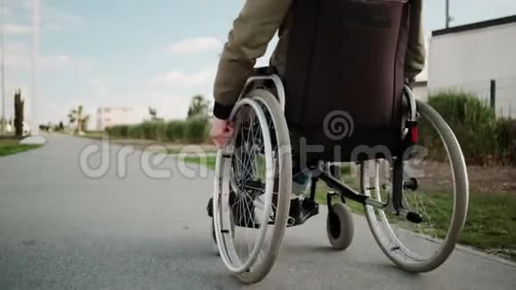 坐轮椅的残疾人正在夏季大街上移动后景视频的预览图