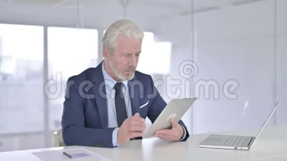 中年商人在办公室的平板电脑上做视频聊天视频的预览图