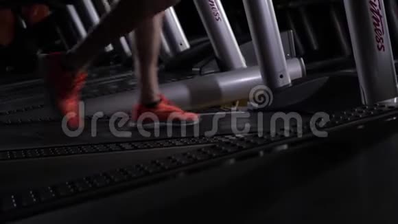 男人脚穿红色运动鞋在跑步机上视频的预览图