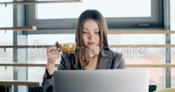 关心的女人喝咖啡在笔记本电脑上工作看着办公室里思考解决问题严重视频的预览图