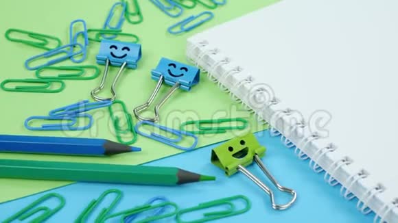 绿色和蓝色办公室回形针微笑活页夹和笔记本上的铅笔视频的预览图