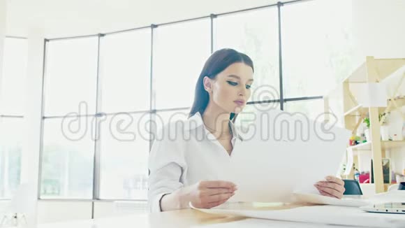 穿着西装的可爱的年轻女子正在处理文件一个雇员适合她讨论这项工作视频的预览图