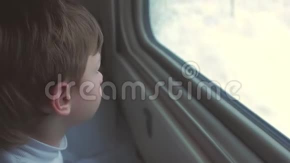 男孩在冬天的风景上看着火车的窗户睡着了躺在床上视频的预览图