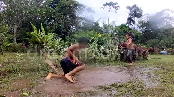 土著儿童在水坑里玩耍视频的预览图