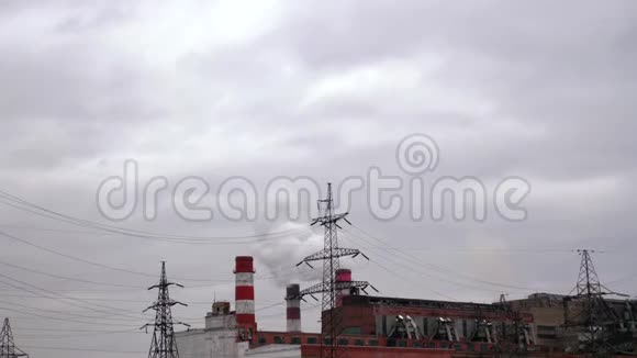 背景下灰色天空的吸烟工业管道和电源线视频的预览图