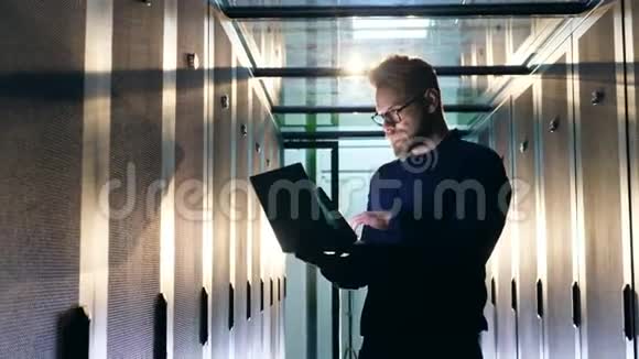 信息技术支助概念男人在笔记本电脑上打字站在服务器房间里视频的预览图