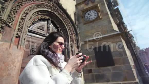 漂亮的微笑女游客用相机拍摄古董建筑的照片视频的预览图