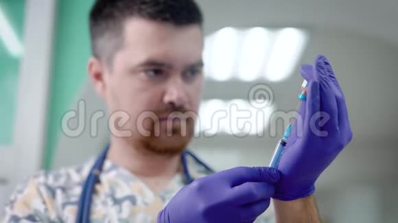 男医生正在用小玻璃瓶中的药物给注射器注入准备在诊所注射视频的预览图
