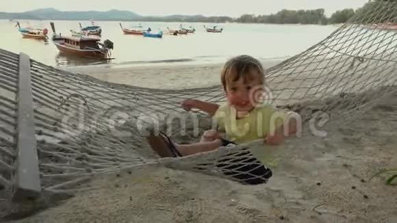 海滩吊床上的快乐男孩视频的预览图