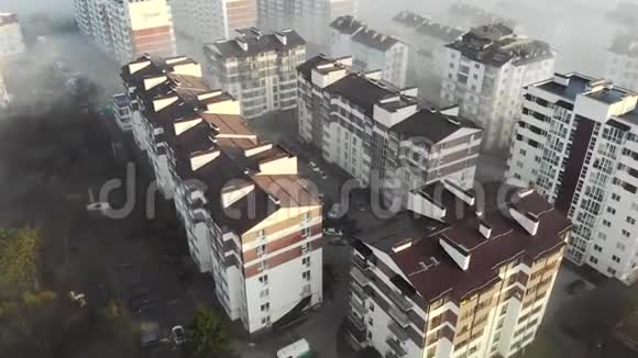 顶部的空中景观在癌雾中飞过房子晨雾中新建高层建筑视频的预览图