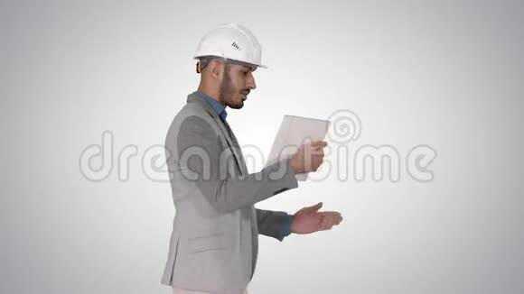 这位时髦的工程师用平板电脑做视频通话显示他在梯度背景下的工作结果视频的预览图