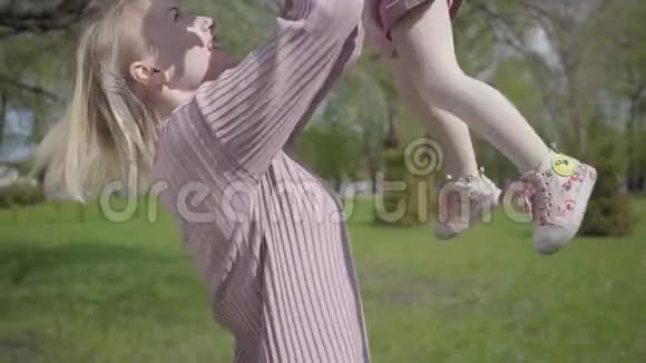 年轻的母亲把她的小女儿抛起来抓住了都笑了快乐无忧无虑的童年在户外休息视频的预览图
