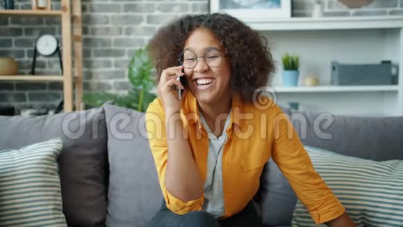美国黑人女孩在公寓里笑着用手机说话视频的预览图