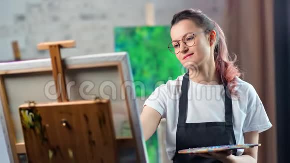 年轻活泼无忧无虑的女画家在工作室画画中特写视频的预览图