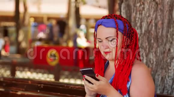 一位坐在公园长椅上的年轻女子在信使中交流视频的预览图