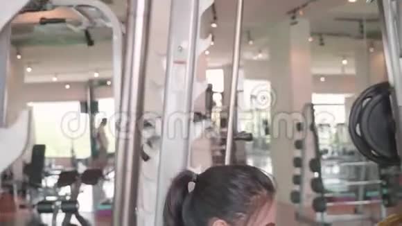 漂亮的亚洲女孩穿着运动服在健身运动健身房举起杠铃运动员生活方式侧视图视频的预览图