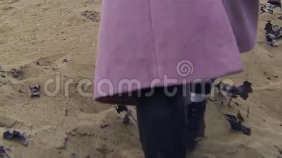 穿着秋靴的女人在沙滩上散步的特写镜头库存录像美丽的年轻女子在多云的沙滩上散步视频的预览图