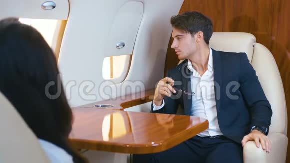 英俊的富人乘坐私人喷气式飞机飞行商务舱旅行中自信的年轻商人视频的预览图