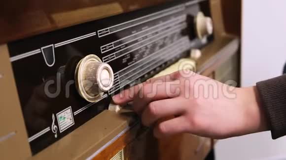 的手转动旧收音机上的旋钮概念老式技术视频的预览图