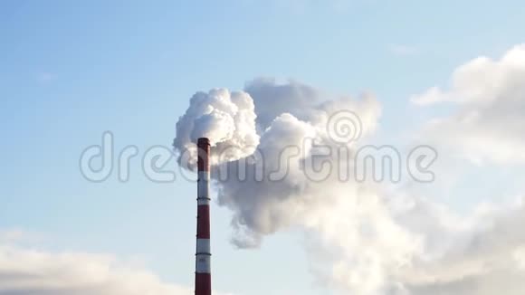 巨大的暖气发电厂的烟囱冒出的浓烟顶着深蓝色的天空视频的预览图