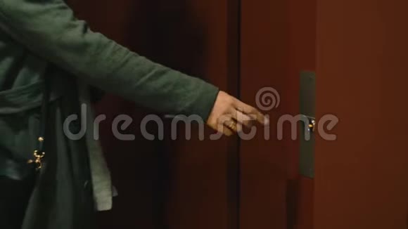 特写镜头穿着优雅的白人女人带着相机按下棕色电梯按钮等待缓慢的动作视频的预览图