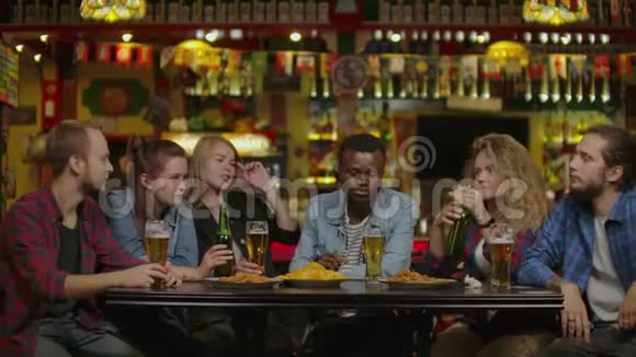 周末朋友在啤酒酒吧餐厅喝啤酒与年轻人一起开心的友谊概念视频的预览图