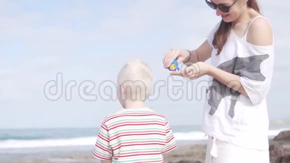 女人用防晒霜抹孩子的脖子视频的预览图