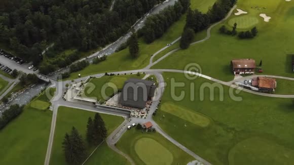 在瑞士阿尔卑斯山的绿色山谷中美丽的小木屋和岩石山河的惊人空中全景拍摄视频的预览图