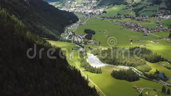 令人叹为观止的空中背景拍摄美丽的小镇和河流在绿色山谷之间的山脉在瑞士阿尔卑斯山视频的预览图