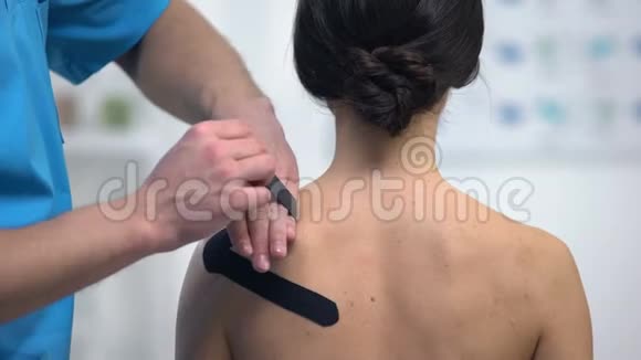 物理治疗师在女性患者肩肌劳损上应用Y形胶带视频的预览图