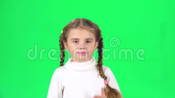 女孩在绿色屏幕上飞吻微笑慢动作视频的预览图