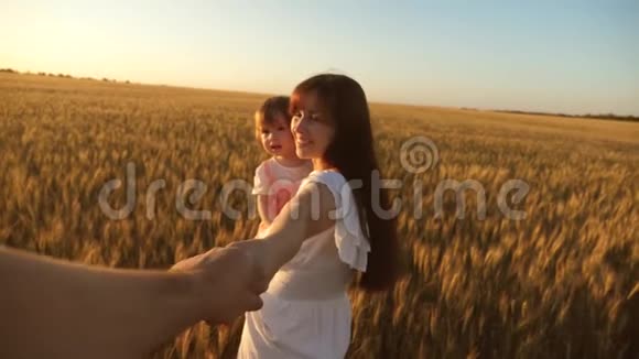 爸爸妈妈和女儿玩牵手团队合作母亲和孩子走在田野里抱着她心爱的男人视频的预览图