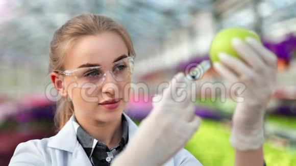 女性化学家用注射器注射成熟绿苹果分析果实品质视频的预览图