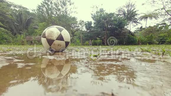 在雨中玩足球的土著儿童视频的预览图