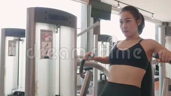 运动年轻女子在健身馆用坐式胸压做运动人的生活方式和运动锻炼健康俱乐部视频的预览图