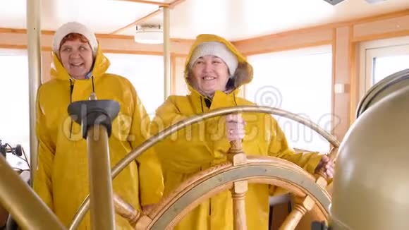 微笑的女船长转动方向盘浮动船女船长驾驶帆船视频的预览图