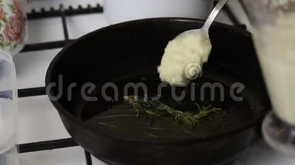 女人炸土豆煎饼一个女人把土豆泥放在热锅上附近躺着一枝迷迭香视频的预览图