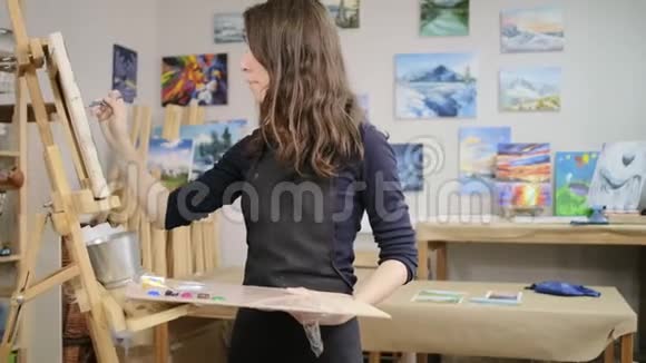 年轻女子正在艺术工作室学习画画在画布上画画视频的预览图