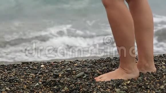 在海浪的背景下女人的腿特写在海岸上休息视频的预览图