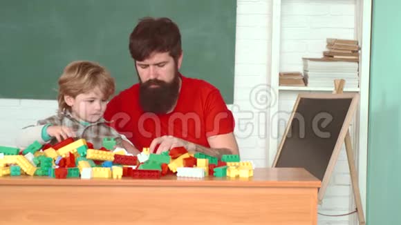 父亲和孩子在家一起帮忙戴着安全帽的儿子帮助他的父亲孩子和父亲在家里做建筑工视频的预览图