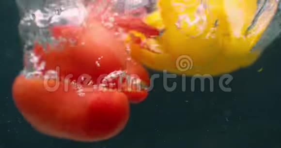 在清澈透明的水中把几片鲜绿黄红的铃椒抛起浮起视频的预览图