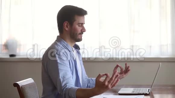 冷静有意识的年轻人休息坐在书桌前冥想视频的预览图