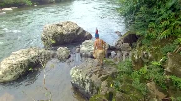 土著战士爬河边的岩石视频的预览图