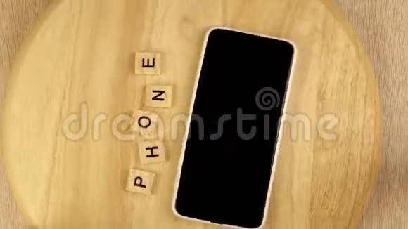 字智能手机和手机在木制平台上360度旋转从上面看到的视频的预览图