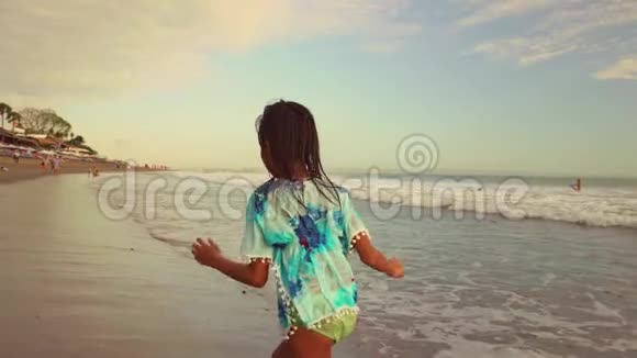 动作慢镜头追踪快乐兴奋的亚洲印尼女孩在海滩上无忧无虑地奔跑视频的预览图