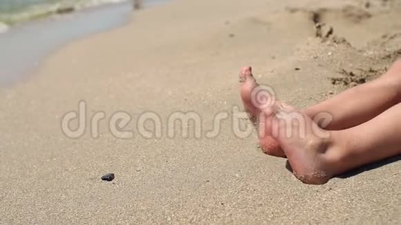 沙滩上一个小孩的脚的特写动作缓慢视频的预览图